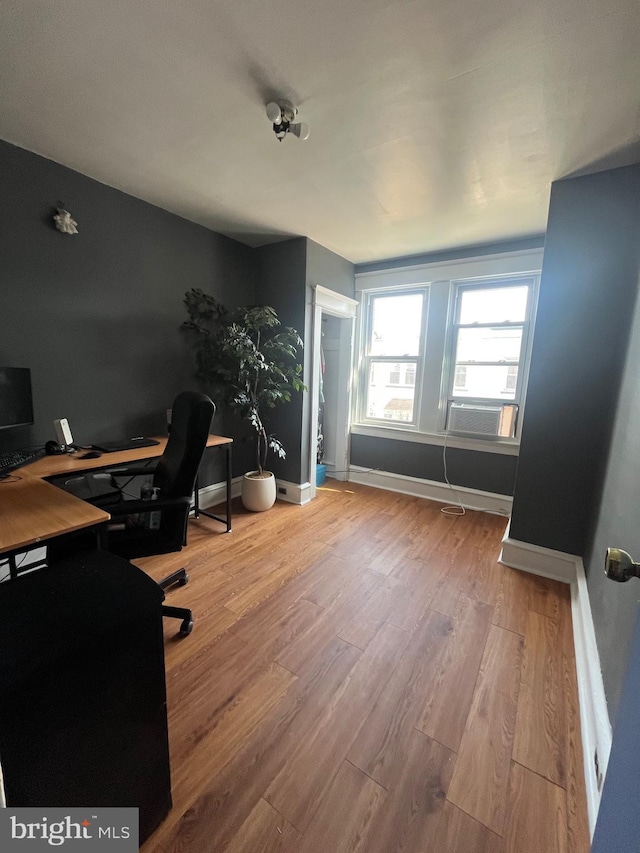 home office with cooling unit, wood finished floors, and baseboards