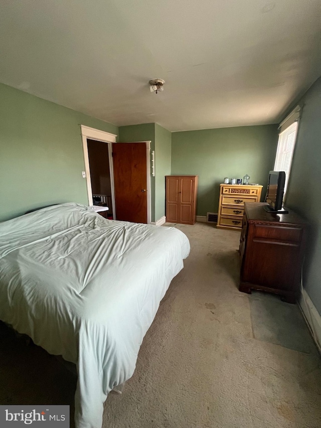 bedroom featuring baseboards and light carpet