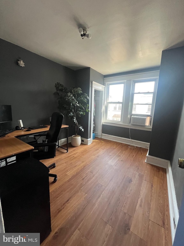 home office with cooling unit, wood finished floors, and baseboards