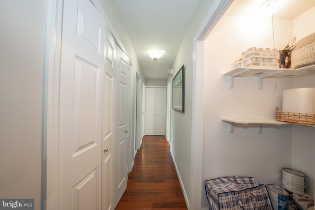 hallway with dark wood-style flooring and baseboards