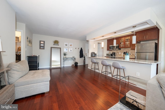 living area with dark wood-type flooring and baseboards