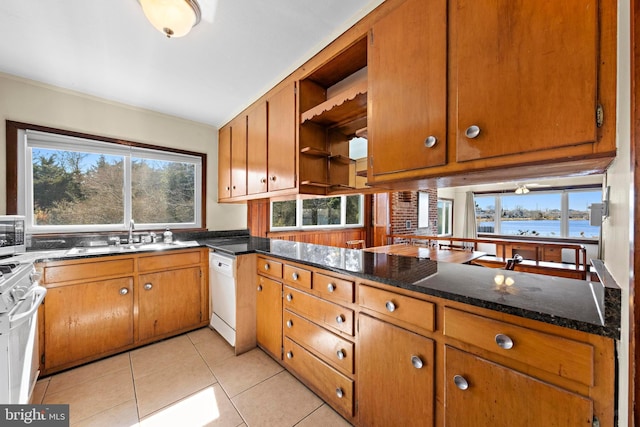 kitchen featuring open shelves, a sink, range with gas cooktop, brown cabinetry, and white dishwasher