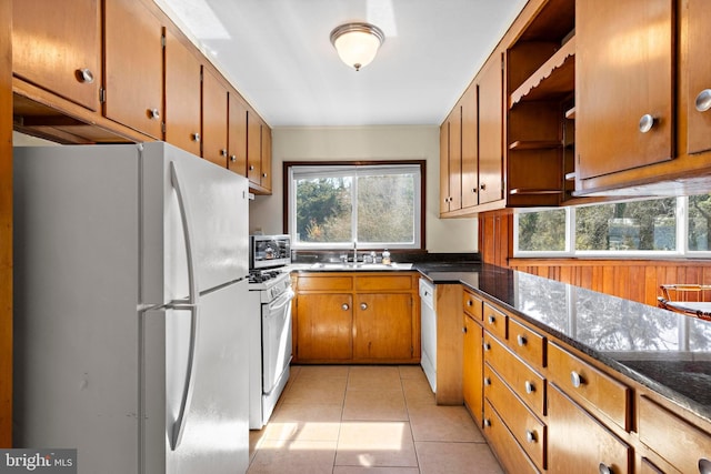 kitchen with white appliances, light tile patterned floors, open shelves, a sink, and brown cabinets