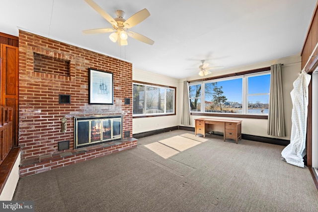 unfurnished sunroom with baseboard heating, a healthy amount of sunlight, a fireplace, and a ceiling fan