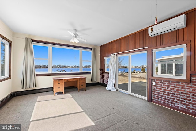 sunroom featuring a wall mounted air conditioner, a ceiling fan, and a water view