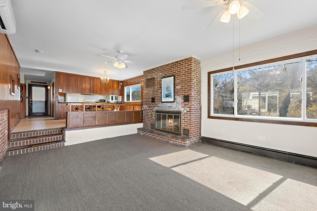 unfurnished living room featuring a ceiling fan, a wall mounted AC, a fireplace, light colored carpet, and baseboard heating