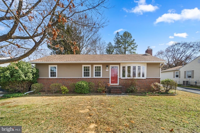 ranch-style home featuring a front yard, brick siding, central AC, and a chimney