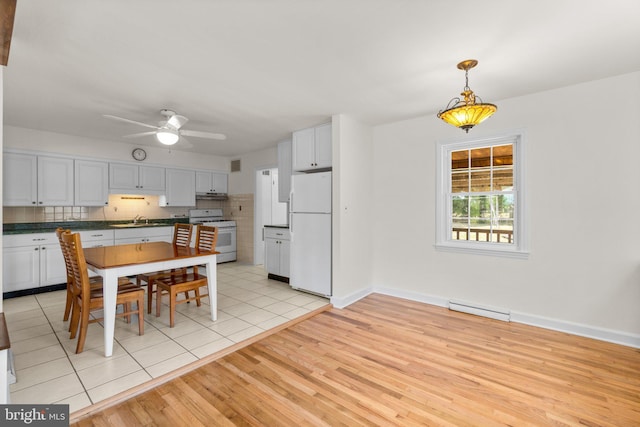 dining space with a ceiling fan, visible vents, light wood-style floors, and baseboards