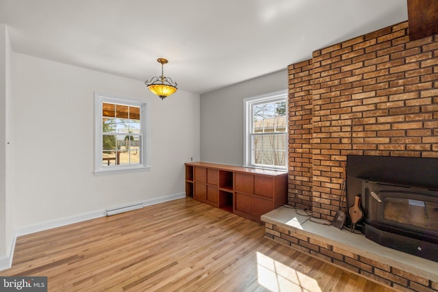 interior space featuring baseboards, a baseboard heating unit, and light wood-style floors