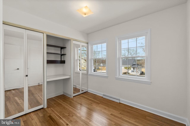 unfurnished bedroom featuring a closet, visible vents, baseboards, and hardwood / wood-style flooring