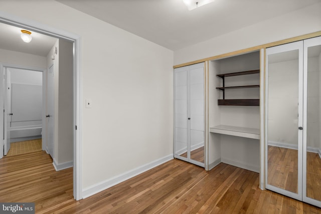 unfurnished bedroom featuring light wood-style floors and baseboards