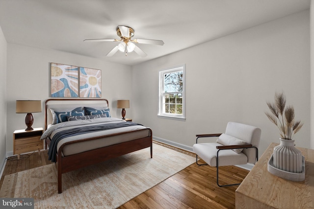 bedroom featuring wood finished floors, baseboards, and ceiling fan