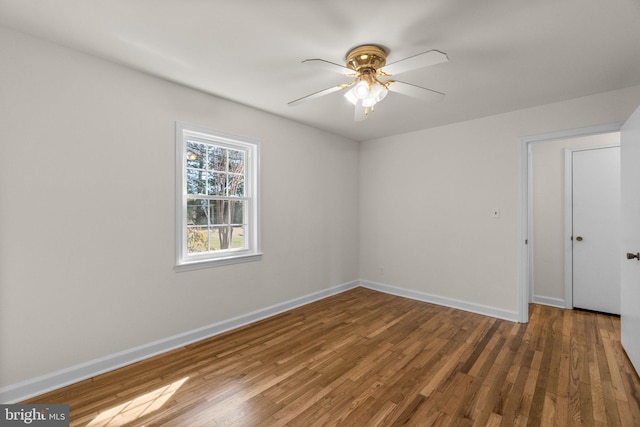 unfurnished room featuring a ceiling fan, baseboards, and wood finished floors