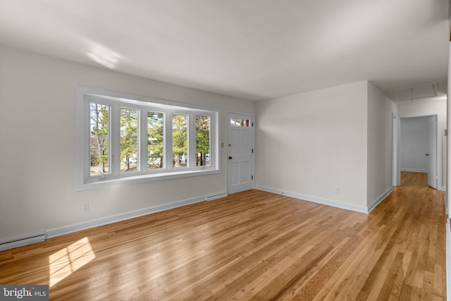 foyer entrance featuring a baseboard heating unit, baseboards, and light wood finished floors