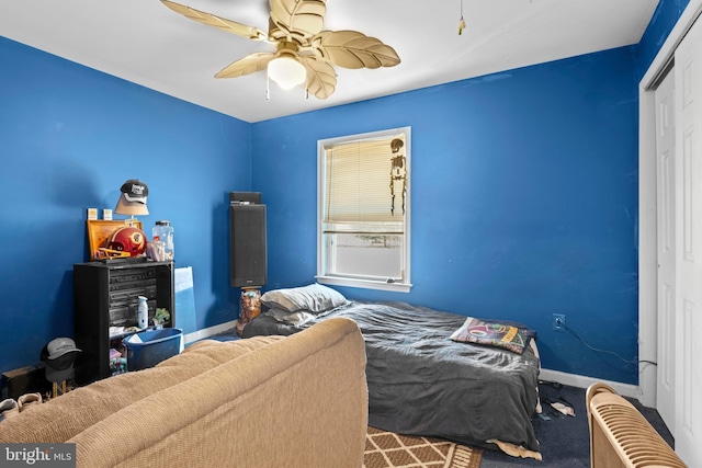 bedroom featuring ceiling fan, carpet, a closet, and baseboards