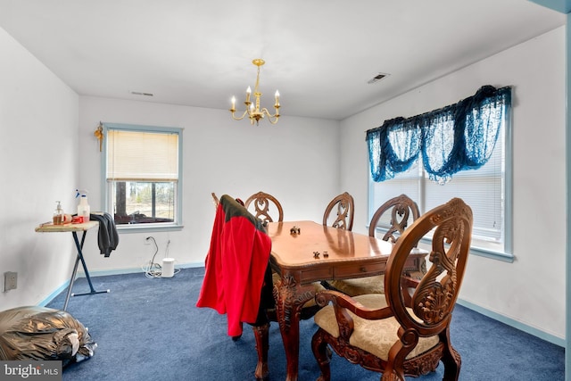 carpeted dining room featuring a notable chandelier, baseboards, and visible vents