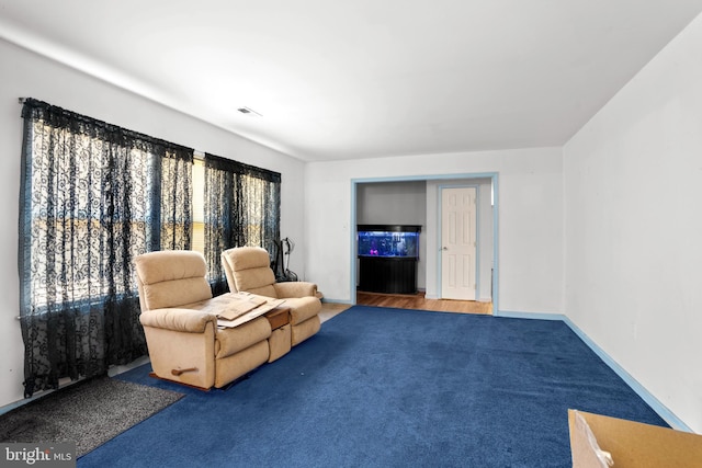 living area featuring visible vents, carpet, and baseboards