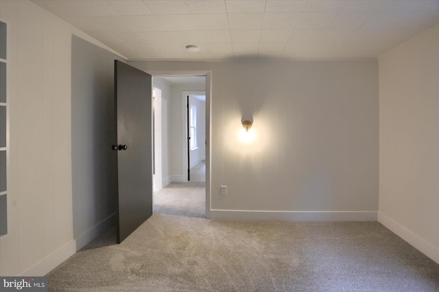 carpeted spare room with baseboards