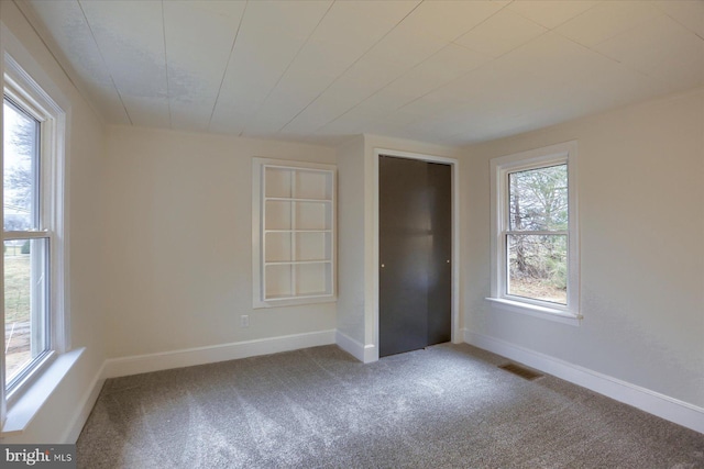 unfurnished bedroom with carpet, visible vents, and baseboards