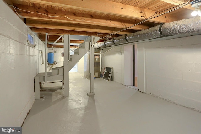 unfinished basement featuring heating unit and concrete block wall