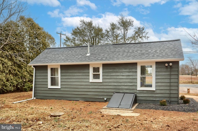 back of house with roof with shingles