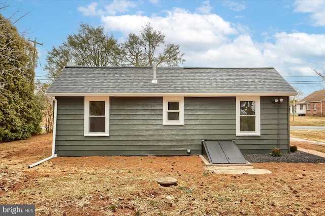 back of property with a shingled roof