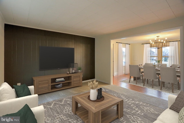 living room featuring baseboards, a chandelier, and wood finished floors