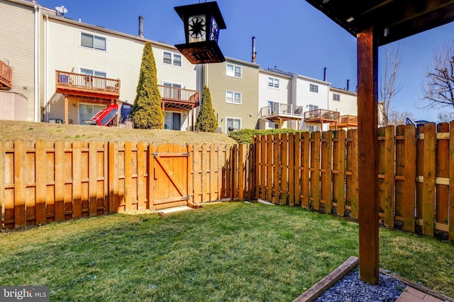 view of yard with a residential view, a fenced backyard, and a gate