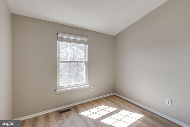 unfurnished room with visible vents, baseboards, and wood finished floors