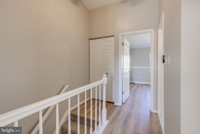 hall with an upstairs landing and light wood-style floors