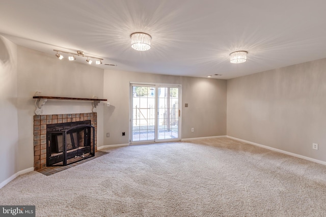 unfurnished living room featuring carpet flooring, baseboards, and a tile fireplace