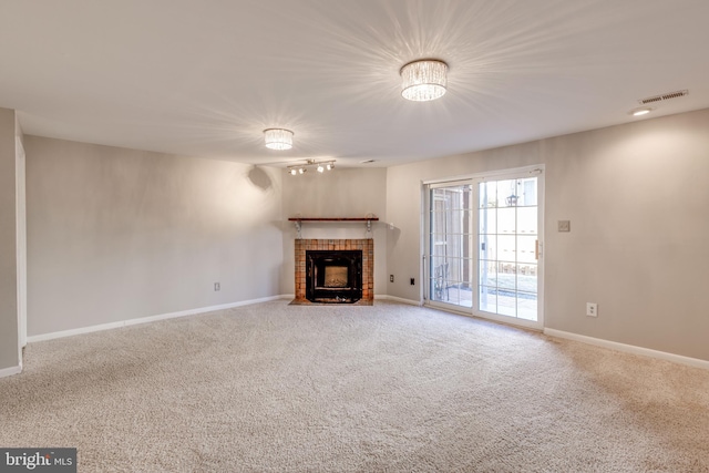 unfurnished living room with visible vents, baseboards, carpet flooring, and a tiled fireplace