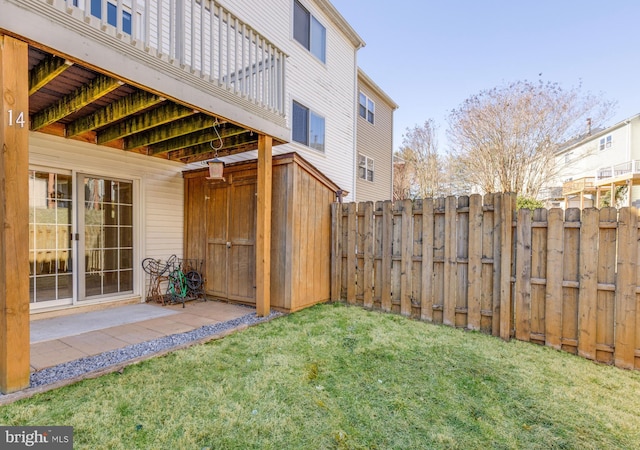 view of yard featuring a patio, an outdoor structure, and fence