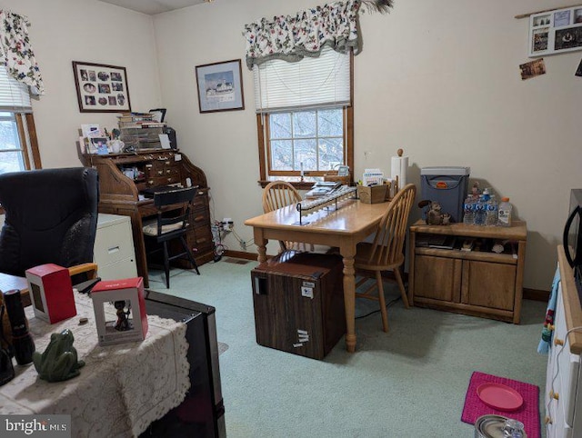 carpeted office space with plenty of natural light and baseboards