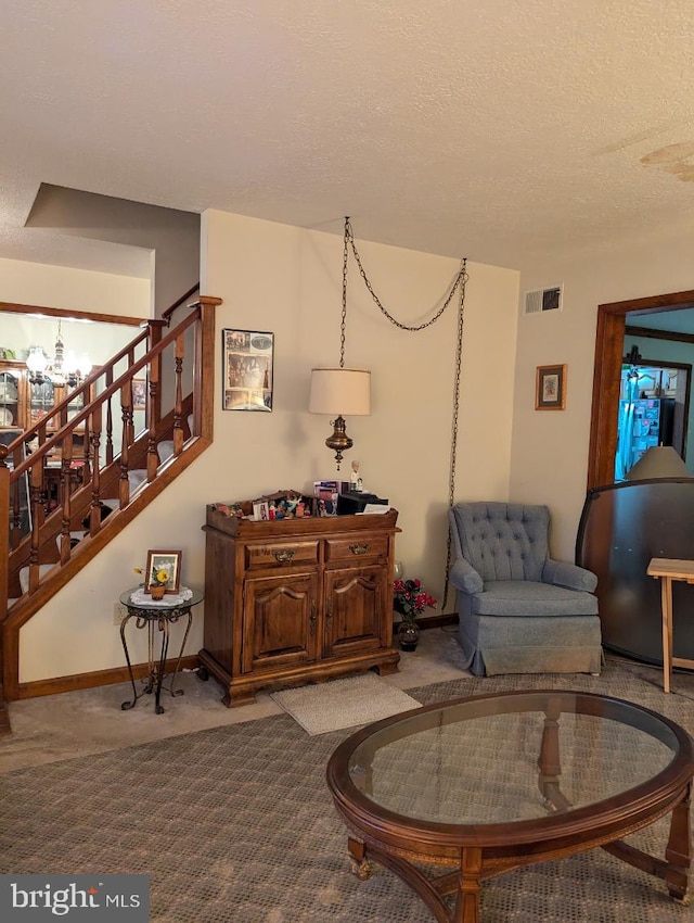 living area featuring visible vents, stairway, carpet flooring, a textured ceiling, and baseboards