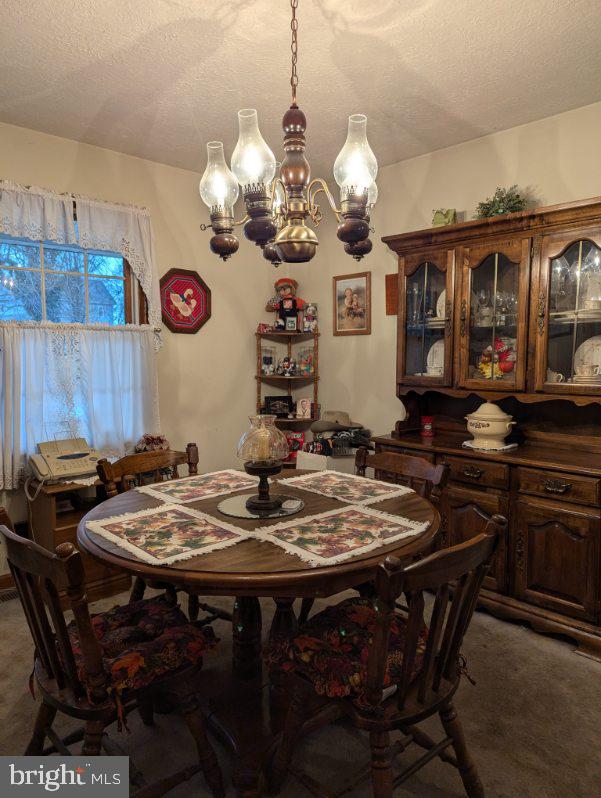 dining space featuring carpet flooring and a textured ceiling