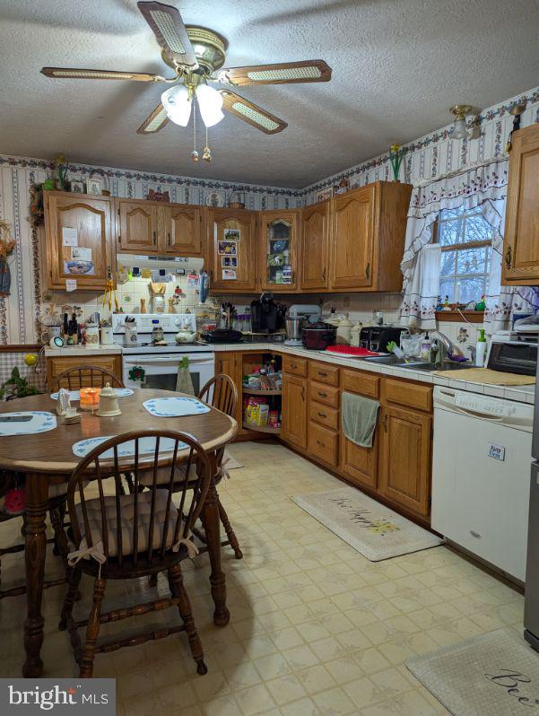 kitchen featuring white appliances, brown cabinetry, and light floors