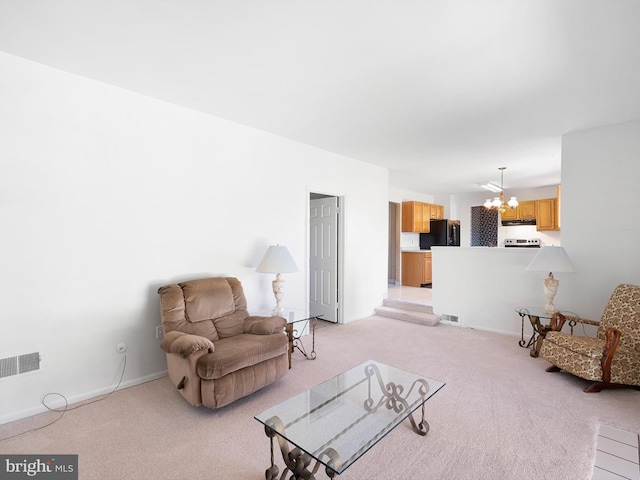 living area with an inviting chandelier, baseboards, visible vents, and light colored carpet