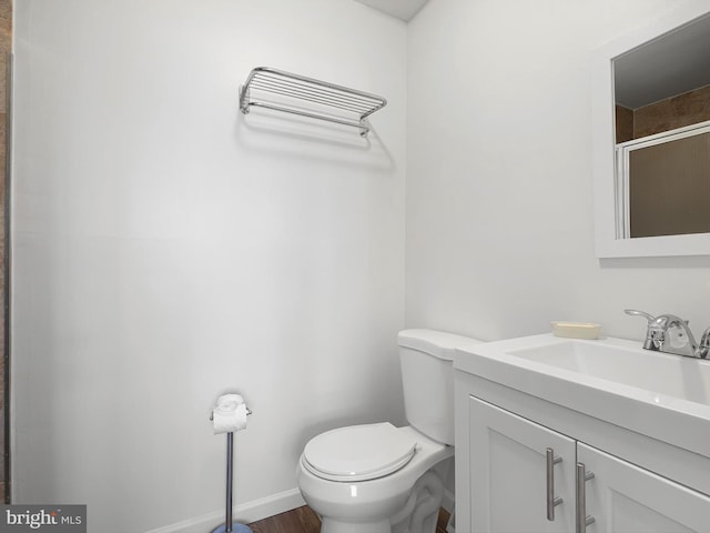 full bathroom with toilet, baseboards, an enclosed shower, and vanity