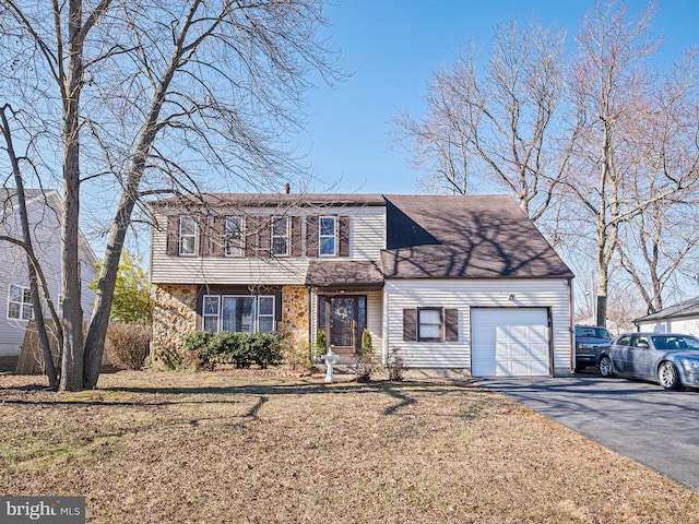 view of front facade with an attached garage, aphalt driveway, and a front yard