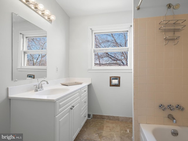 bathroom featuring vanity, baseboards, and bathing tub / shower combination