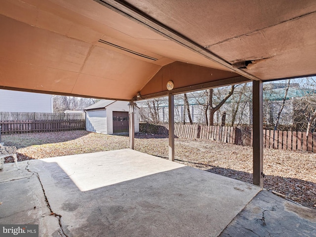 view of patio featuring a fenced backyard, an outdoor structure, and a storage shed