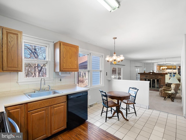 kitchen with a sink, a healthy amount of sunlight, a brick fireplace, decorative backsplash, and dishwasher