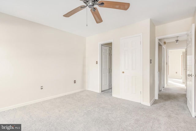 unfurnished bedroom with baseboards, a ceiling fan, and light colored carpet