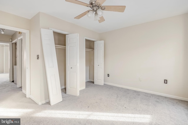 unfurnished bedroom with multiple closets, carpet, and baseboards