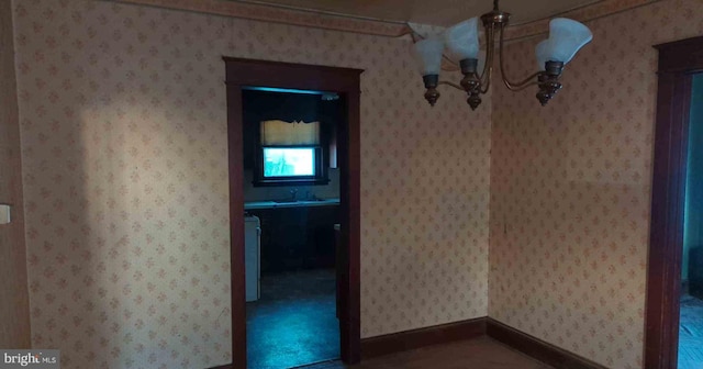 interior space featuring baseboards, washer / clothes dryer, and wallpapered walls