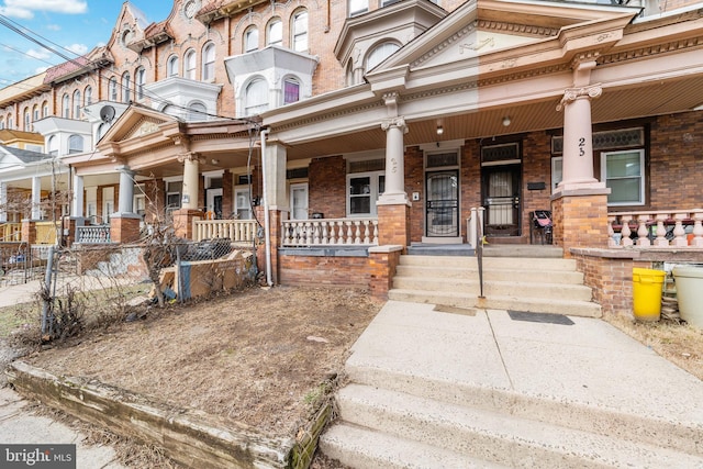 view of front facade with a porch and brick siding