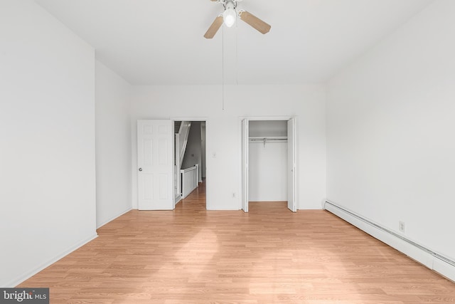 unfurnished bedroom with a ceiling fan, a closet, light wood-style flooring, and baseboard heating