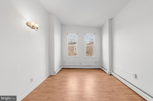 unfurnished room featuring lofted ceiling, light wood-type flooring, a baseboard radiator, and baseboards