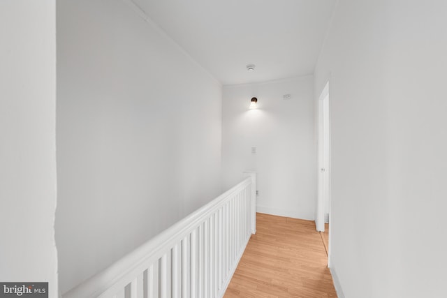 corridor featuring light wood finished floors and baseboards